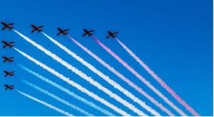 The Red Arrows flying in arrowhead formation through a blue sky