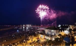 Fireworks exploding in the sky over the iconic harbour at Lyme Regis, Dorset