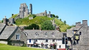 Corfe castle in Dorset, surrounded by green hills and white cottages