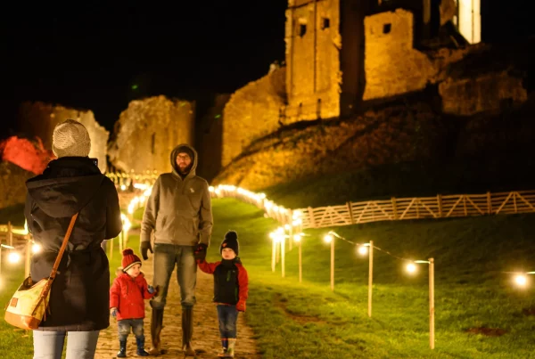 A family walk through Christmas lights at Corfe Castle, Dorset