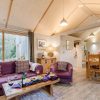The interior of a Burnbake luxury lodge with purple sofa and wooden furnishings.