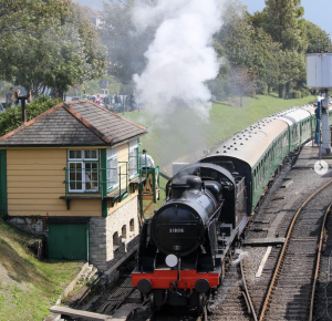 Steam locomotive travels through Swanage railway station, Dorset.