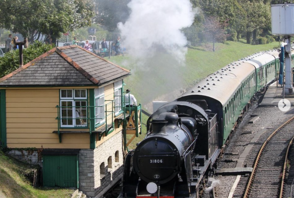 Steam locomotive travels through Swanage railway station, Dorset.