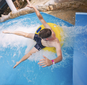 Man travels through water park ride on yellow inflatable ring.