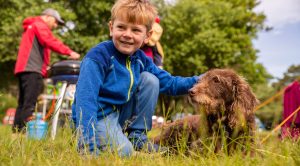 Young boy petting his dog when camping