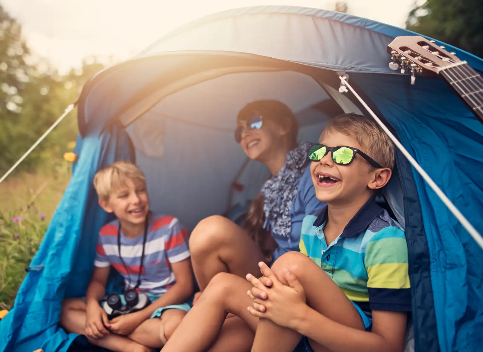Boys and girls laughing in a tent in the summer